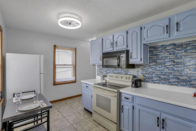 6880 Sandusky Ave, Chatfield, OH 44825 - kitchen with white appliances, backsplash, light countertops, blue cabinets, and light tile patterned flooring