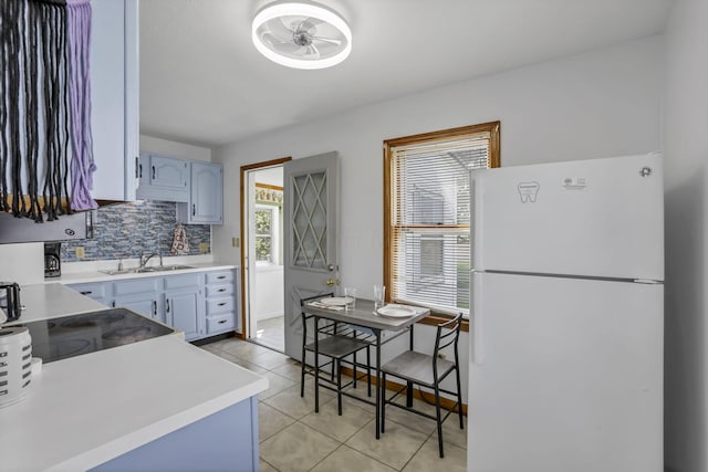 6880 Sandusky Ave, Chatfield, OH 44825 - kitchen with freestanding refrigerator, light countertops, light tile patterned flooring, backsplash, and a sink