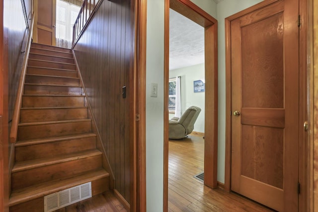 6880 Sandusky Ave, Chatfield, OH 44825 - stairway featuring hardwood / wood-style floors, a textured ceiling, and baseboards