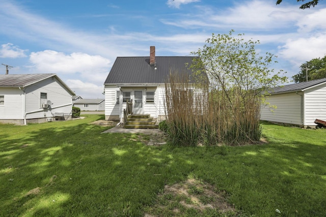 6880 Sandusky Ave, Chatfield, OH 44825 - rear view of house featuring a chimney, metal roof, a yard, and entry steps