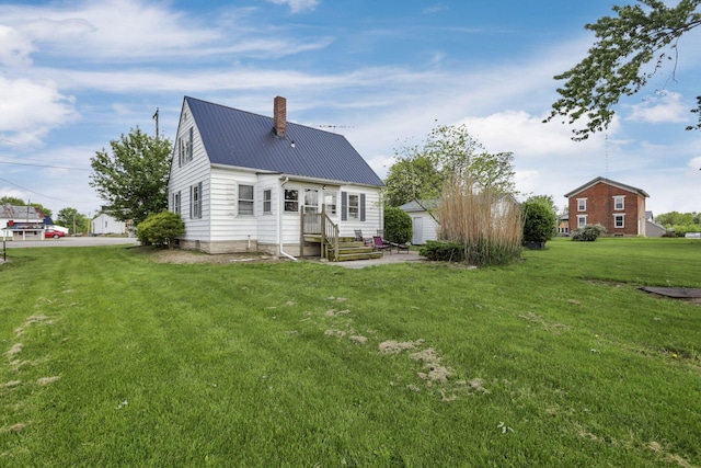 6880 Sandusky Ave, Chatfield, OH 44825 - back of property featuring a chimney, metal roof, and a yard