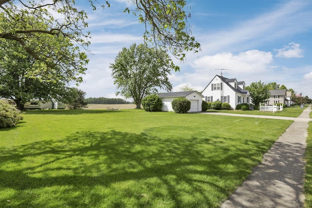 6880 Sandusky Ave, Chatfield, OH 44825 - view of green lawn featuring driveway, a garage, and an outbuilding