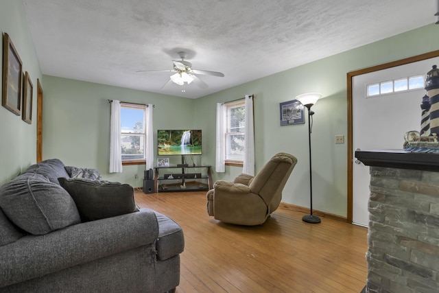 6880 Sandusky Ave, Chatfield, OH 44825 - living area featuring hardwood / wood-style floors, a ceiling fan, a textured ceiling, and baseboards