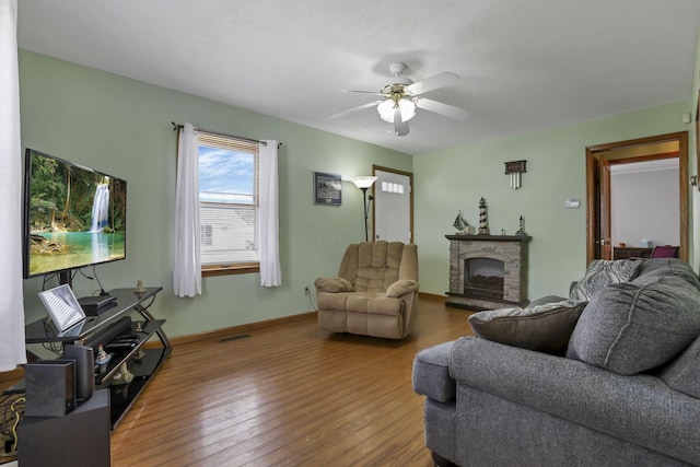 6880 Sandusky Ave, Chatfield, OH 44825 - living room featuring a ceiling fan, hardwood / wood-style floors, a fireplace, and baseboards