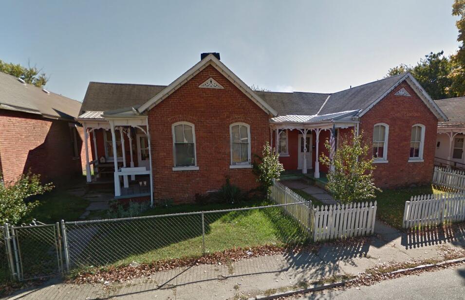 384 E 2nd St, Chillicothe, OH 45601 - view of front of home with brick siding, covered porch, and a fenced front yard