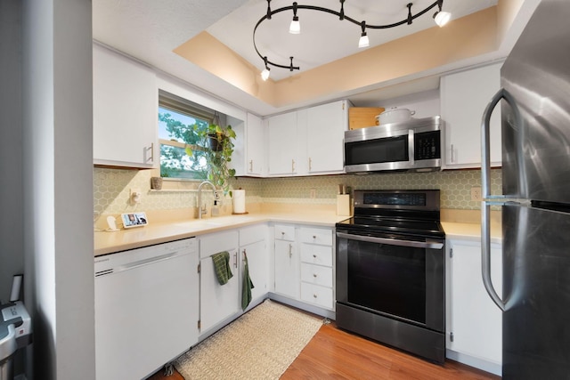 7914 Verandah Ct Unit 61, Powell, OH 43065 - kitchen with appliances with stainless steel finishes, a sink, light countertops, and white cabinetry