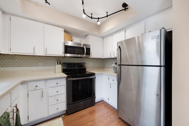 7914 Verandah Ct Unit 61, Powell, OH 43065 - kitchen with appliances with stainless steel finishes, light wood-style floors, light countertops, white cabinets, and backsplash