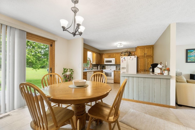 5081 Carters Corner Rd, Sunbury, OH 43074 - dining area with light tile patterned flooring, a chandelier, and a textured ceiling