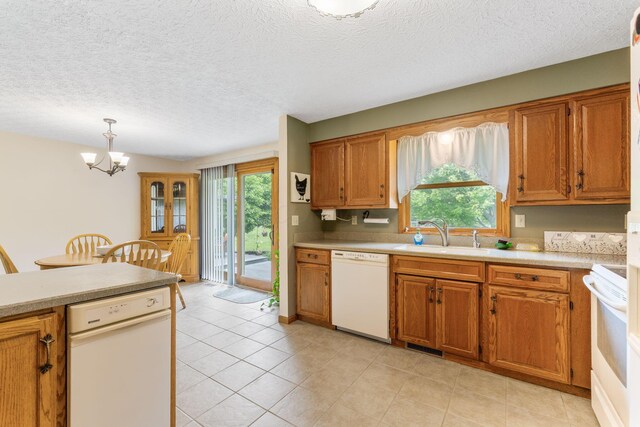 5081 Carters Corner Rd, Sunbury, OH 43074 - kitchen featuring dishwasher, a sink, a chandelier, brown cabinetry, and light countertops