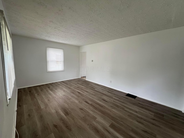 101 N James Rd, Columbus, OH 43213 - empty room with a textured ceiling, dark wood-type flooring, and baseboards