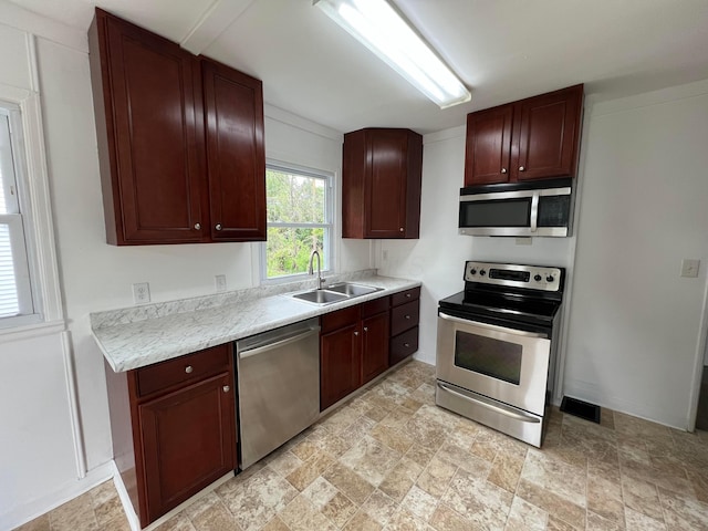 101 N James Rd, Columbus, OH 43213 - kitchen with appliances with stainless steel finishes, a sink, light countertops, light stone finish flooring, and baseboards