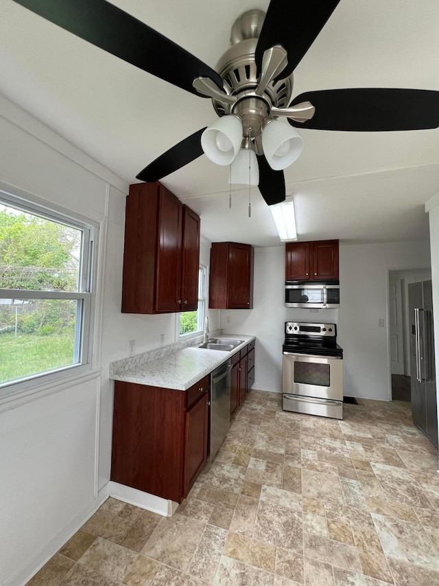 101 N James Rd, Columbus, OH 43213 - kitchen with appliances with stainless steel finishes, a ceiling fan, light countertops, and stone finish flooring