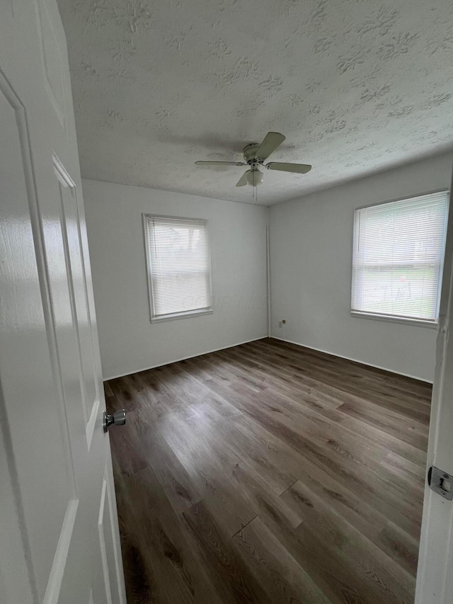 101 N James Rd, Columbus, OH 43213 - spare room featuring a textured ceiling, dark wood-style floors, healthy amount of natural light, and a ceiling fan