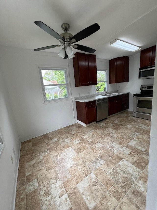 101 N James Rd, Columbus, OH 43213 - kitchen featuring appliances with stainless steel finishes, light stone finish flooring, light countertops, a sink, and a ceiling fan