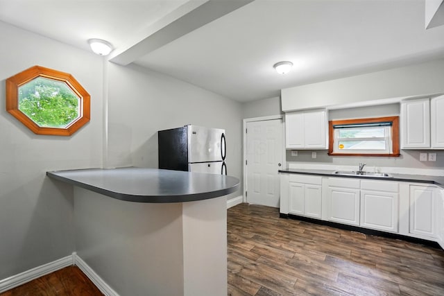 760-762 Kelton Ave, Columbus, OH 43205 - kitchen with freestanding refrigerator, a sink, a peninsula, dark wood-type flooring, and white cabinets
