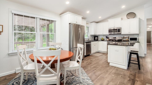 2145 Welsh Hills Rd NE, Granville, OH 43023 - kitchen featuring appliances with stainless steel finishes, a sink, white cabinetry, vaulted ceiling, and light wood-style floors