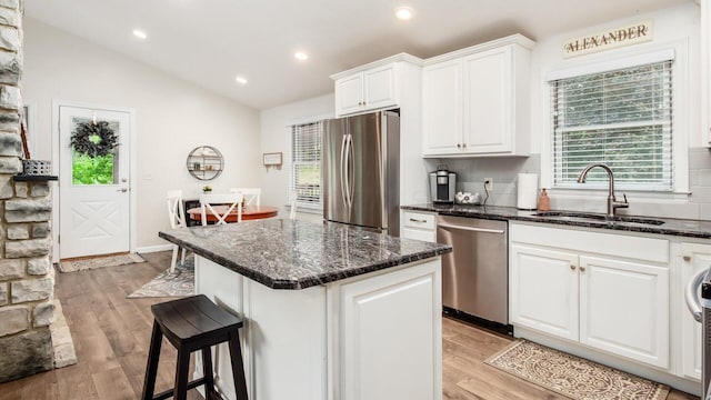 2145 Welsh Hills Rd NE, Granville, OH 43023 - kitchen with appliances with stainless steel finishes, a sink, a breakfast bar, white cabinets, and light wood-style floors
