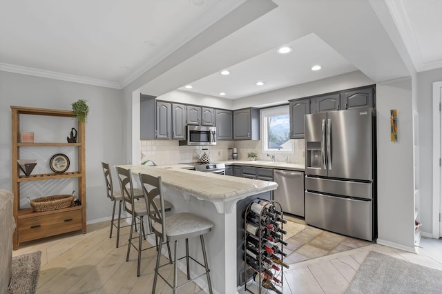4945 Walnut Rd Unit 6, Buckeye Lake, OH 43008 - kitchen with stainless steel appliances, gray cabinets, a breakfast bar, a peninsula, and crown molding