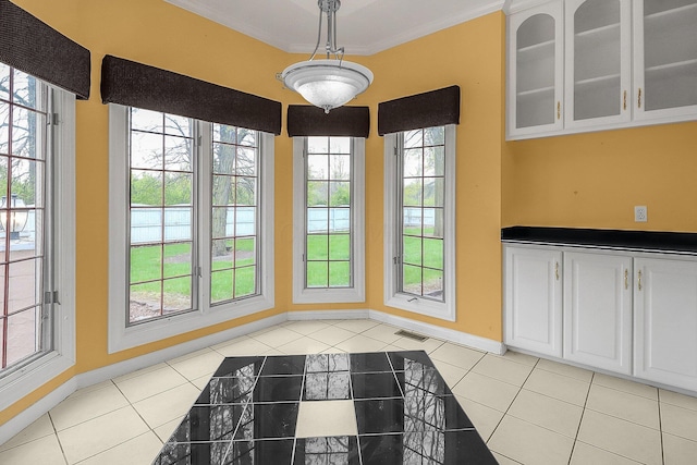 736 Eton St, Marion, OH 43302 - unfurnished dining area with light tile patterned floors, healthy amount of natural light, baseboards, and ornamental molding