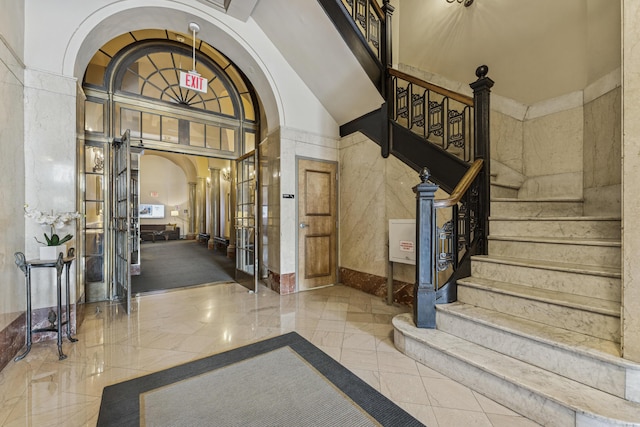 145 N High St Unit 300, Columbus, OH 43215 - foyer entrance featuring arched walkways, ornate columns, marble tiled floors, stairs, and a high ceiling
