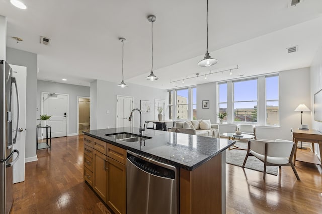 145 N High St Unit 300, Columbus, OH 43215 - kitchen featuring appliances with stainless steel finishes, a sink, dark wood-style flooring, dark stone countertops, and brown cabinetry