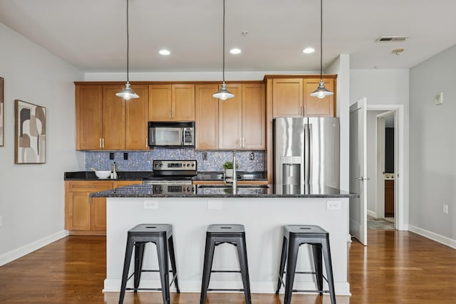 145 N High St Unit 300, Columbus, OH 43215 - kitchen featuring stainless steel appliances, a center island with sink, tasteful backsplash, a breakfast bar, and recessed lighting
