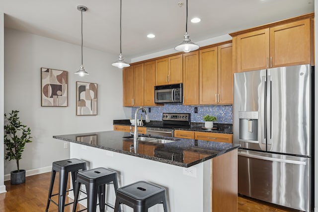 145 N High St Unit 300, Columbus, OH 43215 - kitchen with stainless steel appliances, backsplash, baseboards, an island with sink, and dark wood finished floors