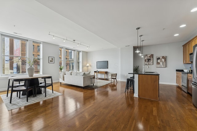 145 N High St Unit 300, Columbus, OH 43215 - kitchen with dark countertops, electric range, a kitchen bar, open floor plan, and dark wood-style floors