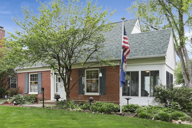 1470 Berkshire Rd, Columbus, OH 43221 - view of front of home with brick siding, roof with shingles, a front lawn, and a sunroom