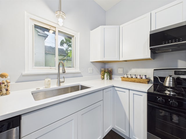 715 N Broad St, Lancaster, OH 43130 - kitchen featuring appliances with stainless steel finishes, a sink, light countertops, white cabinets, and pendant lighting