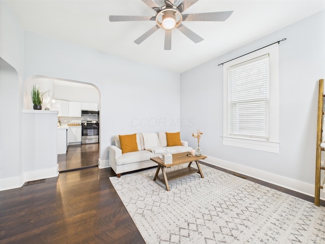 715 N Broad St, Lancaster, OH 43130 - living area featuring ceiling fan, baseboards, arched walkways, and dark wood finished floors