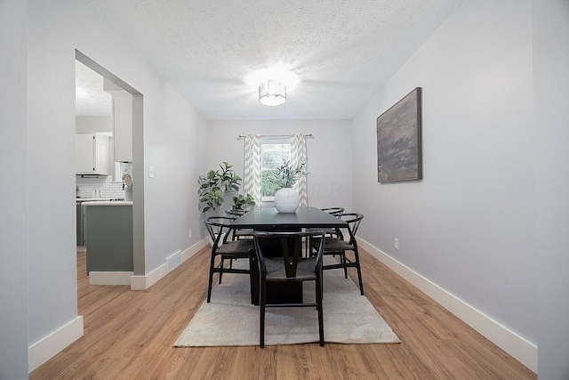 13789 Cobblestone Ln, Pickerington, OH 43147 - dining space featuring light wood-style flooring, baseboards, and a textured ceiling