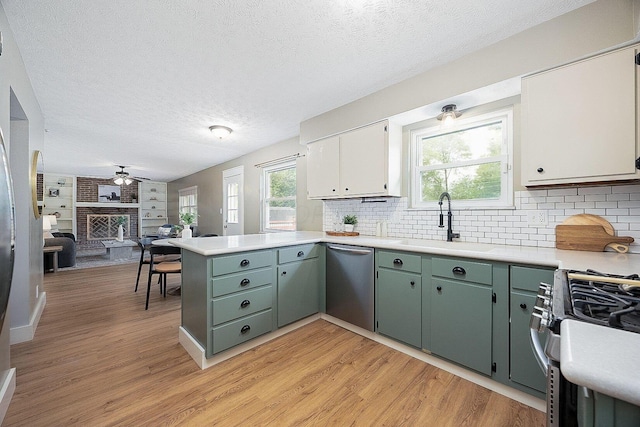 13789 Cobblestone Ln, Pickerington, OH 43147 - kitchen with appliances with stainless steel finishes, a peninsula, light wood-style floors, light countertops, and a textured ceiling