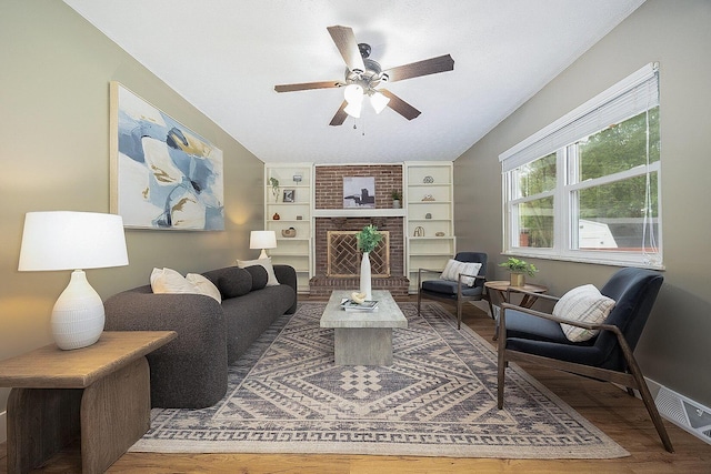 13789 Cobblestone Ln, Pickerington, OH 43147 - living area featuring a ceiling fan, wood finished floors, built in features, a brick fireplace, and baseboards