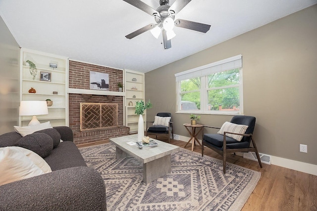 13789 Cobblestone Ln, Pickerington, OH 43147 - living area featuring wood finished floors, a ceiling fan, baseboards, and a brick fireplace