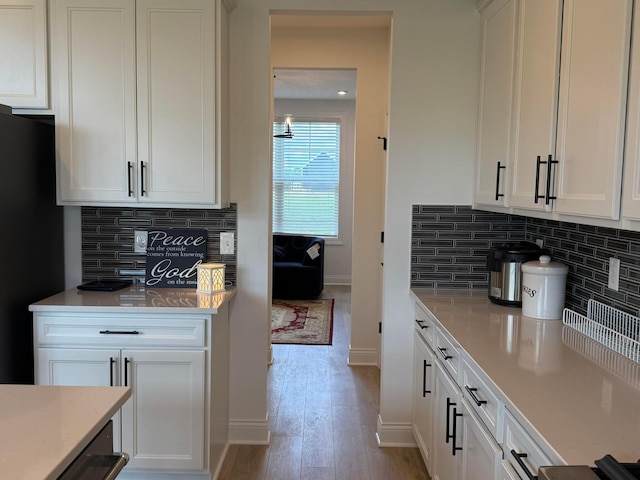 2497 Nelson Ln, Delaware, OH 43015 - kitchen featuring white cabinets, baseboards, light wood-style floors, and decorative backsplash
