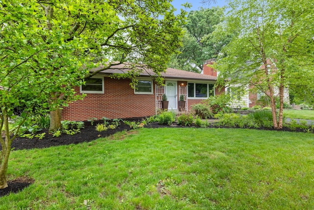 2629 Woodley Rd, Columbus, OH 43231 - view of front of house featuring a front yard, a chimney, and brick siding