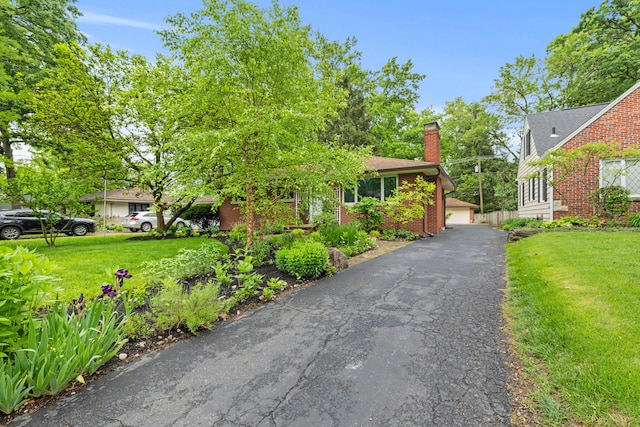 2629 Woodley Rd, Columbus, OH 43231 - view of front facade with a front yard, a chimney, and brick siding