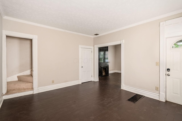 815 Hamlet St, Columbus, OH 43215 - entryway featuring stairs, dark wood-style flooring, a textured ceiling, a fireplace, and crown molding