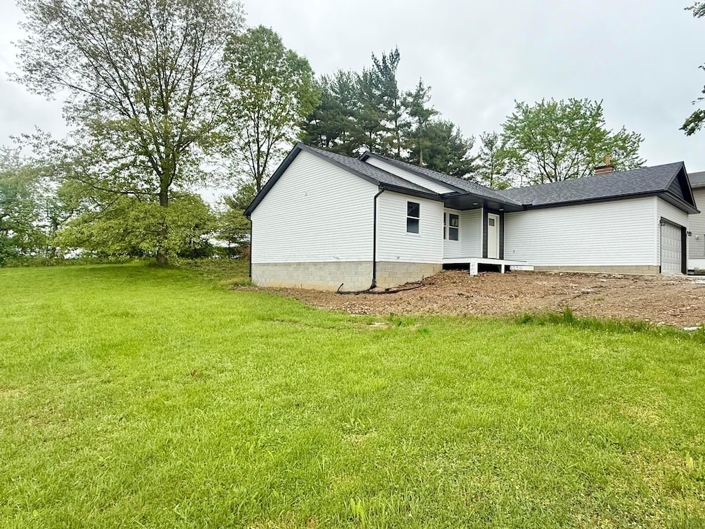 129 Hasbrouck Cir, Howard, OH 43028 - view of property exterior featuring an attached garage, a yard, and a chimney