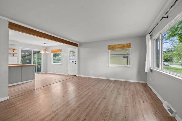1296 Bryson Rd, Columbus, OH 43224 - unfurnished living room with wood finished floors, baseboards, beamed ceiling, and a chandelier