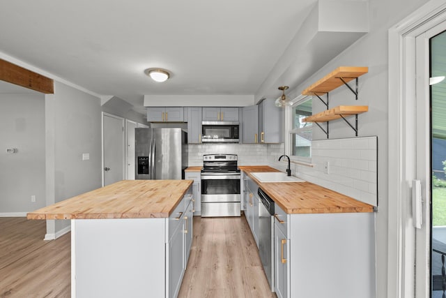 1296 Bryson Rd, Columbus, OH 43224 - kitchen featuring wood counters, stainless steel appliances, a sink, light wood finished floors, and backsplash