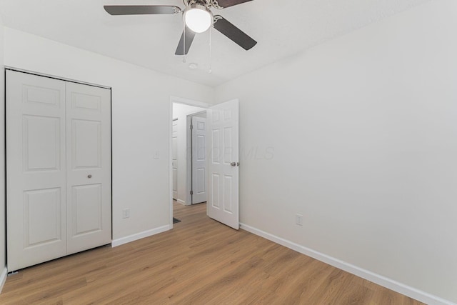 1747 E 25th Ave, Columbus, OH 43219 - unfurnished bedroom with baseboards, light wood-style floors, a closet, and ceiling fan