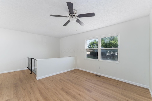 1747 E 25th Ave, Columbus, OH 43219 - unfurnished room with light wood-style floors, a textured ceiling, baseboards, and ceiling fan