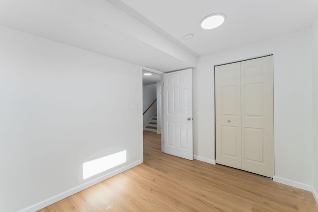 1747 E 25th Ave, Columbus, OH 43219 - unfurnished bedroom featuring baseboards, wood finished floors, and a closet