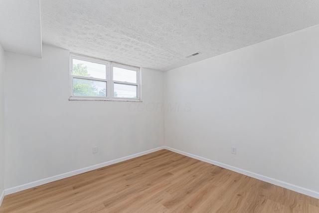 1747 E 25th Ave, Columbus, OH 43219 - unfurnished room featuring light wood-type flooring, baseboards, and a textured ceiling