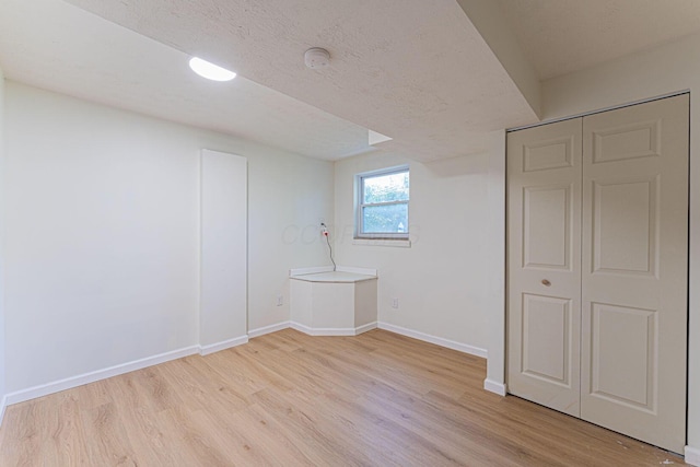 1747 E 25th Ave, Columbus, OH 43219 - basement with light wood-style floors, baseboards, and a textured ceiling