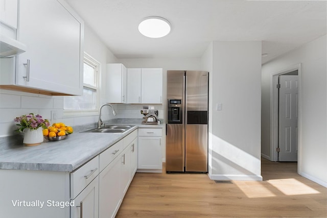 1747 E 25th Ave, Columbus, OH 43219 - kitchen featuring stainless steel fridge with ice dispenser, a sink, light wood-style floors, white cabinets, and tasteful backsplash