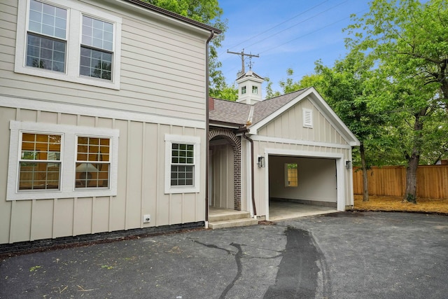 1884 W Lane Ave, Columbus, OH 43221 - view of front facade featuring driveway, board and batten siding, a garage, and roof with shingles