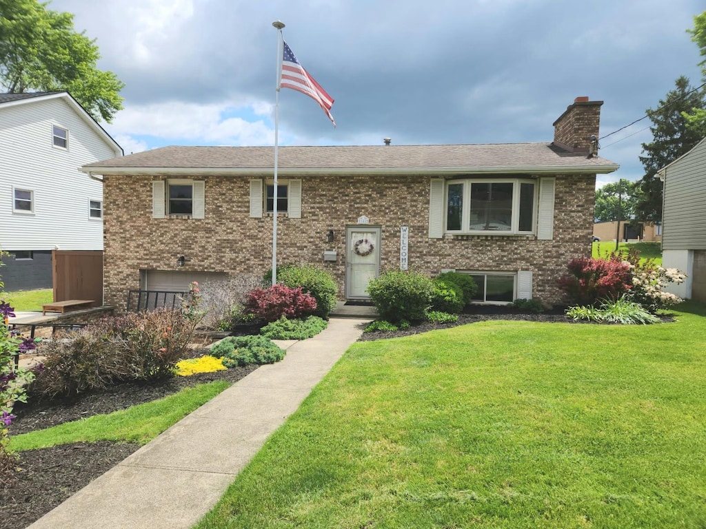 148 N Ohio Ave, Lancaster, OH 43130 - split foyer home with a front lawn, a chimney, brick siding, and a shingled roof